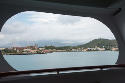 City at waterfront against cloudy sky