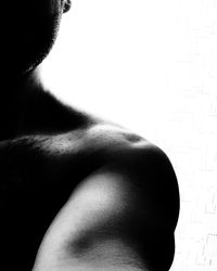 Rear view of shirtless man against black background