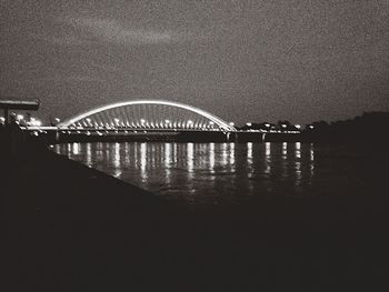 Bridge over river against sky at night