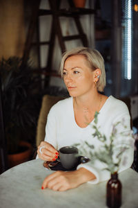 Midsection of woman drinking coffee