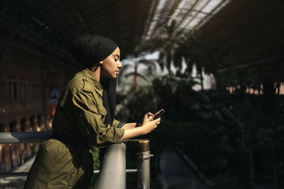 Portrait of modern muslim woman using her smartphone on a train station