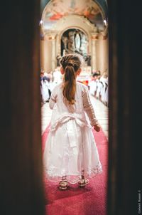 Rear view of woman standing in temple