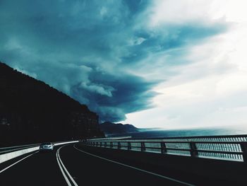 Empty road against cloudy sky