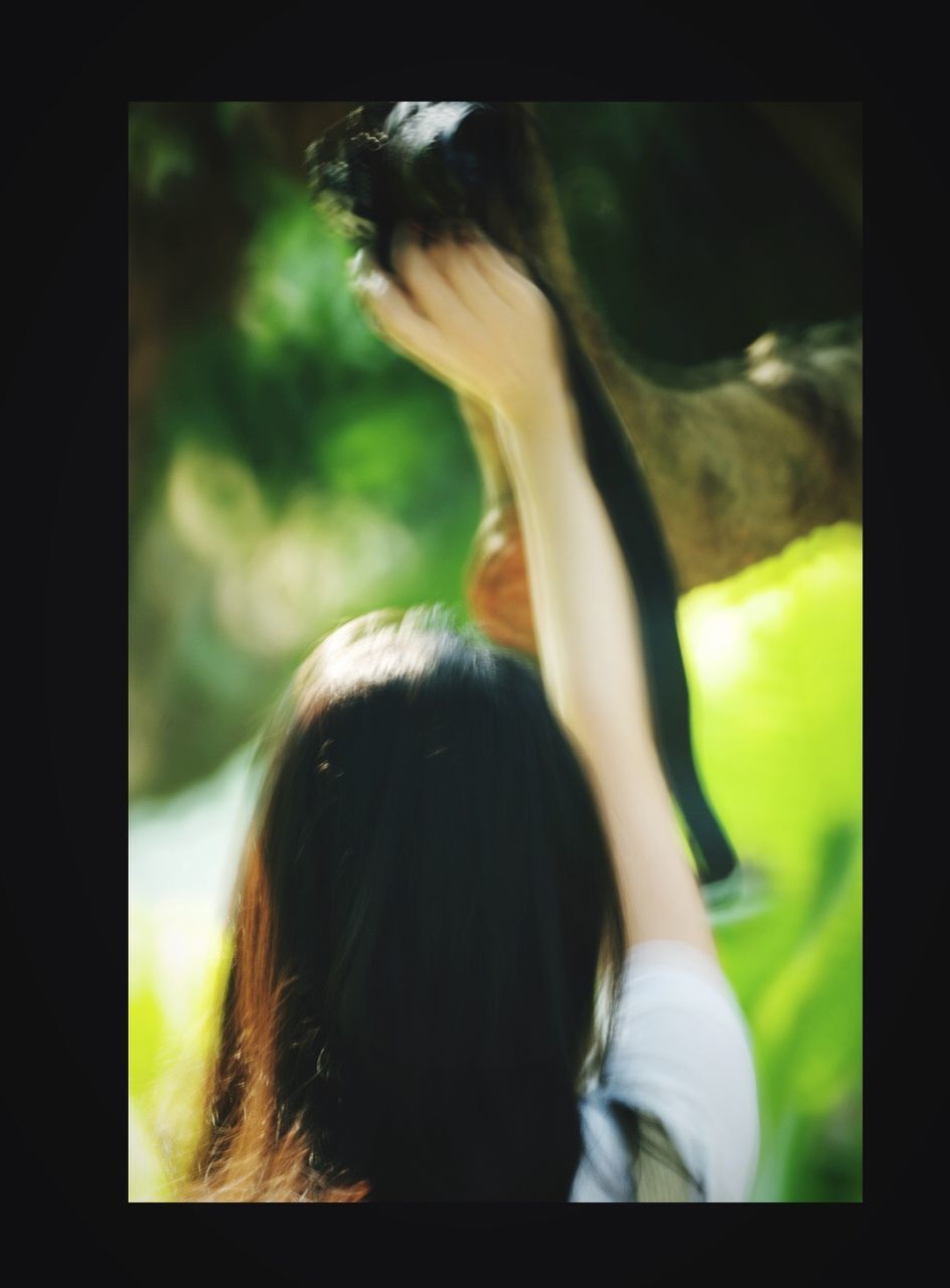 REAR VIEW OF WOMAN STANDING IN MIRROR