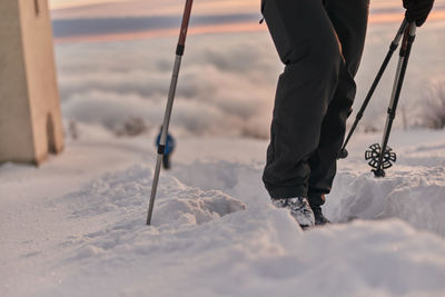 Low section of person standing on snow covered land