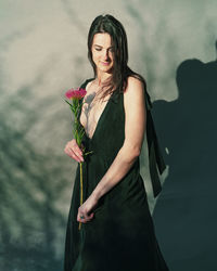 Young woman standing against wall