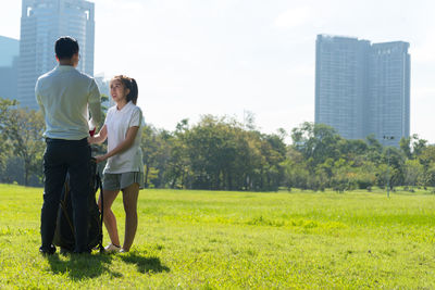 Full length of couple playing golf on field