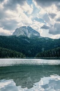 Scenic view of lake by mountains against sky