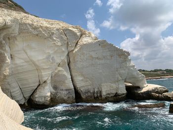 Rock formation in sea against sky