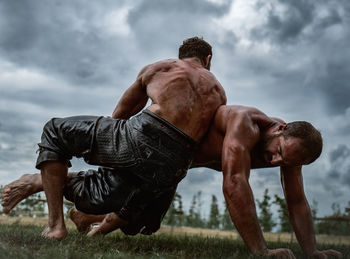 Full length of shirtless man on field