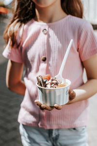 Portrait of a beautiful caucasian girl having ice cream in the city.