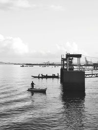 People on boat in sea against sky