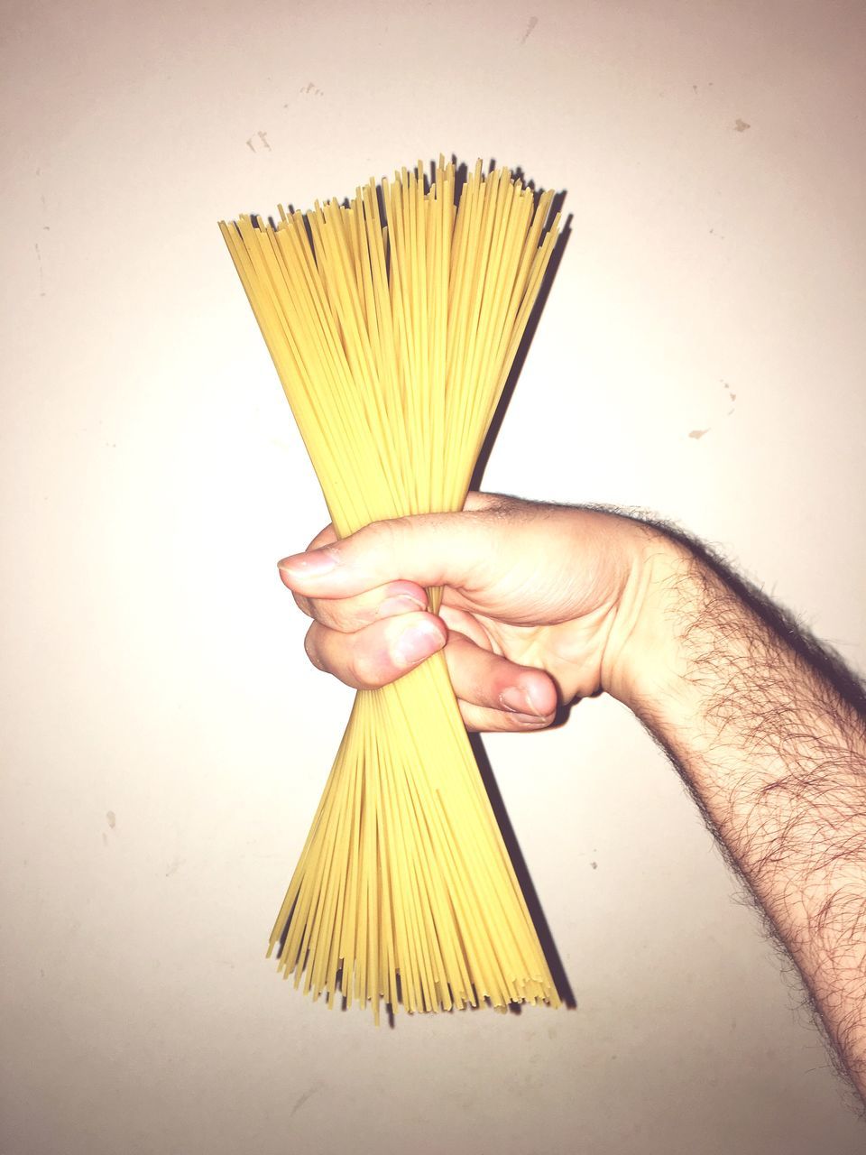 pasta, human hand, spaghetti, holding, food and drink, one person, human body part, food, italian food, real people, healthy eating, bundle, indoors
