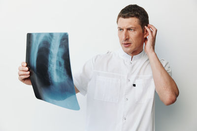 Young man using mobile phone against white background