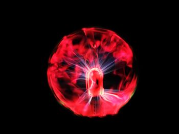 Close-up of illuminated lighting equipment against black background