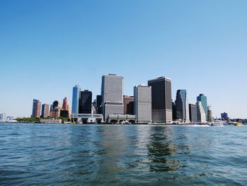 City at waterfront against blue sky