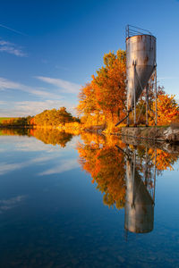 Built structure by lake against sky during autumn