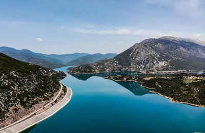 Scenic view of lake by mountains against sky