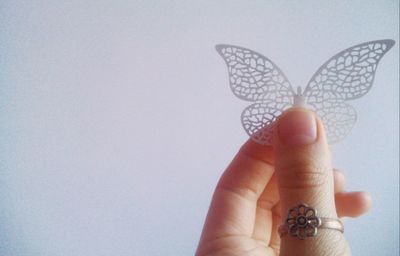 Close-up of hand holding hands over white background