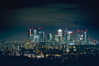 Illuminated buildings in city against sky at night