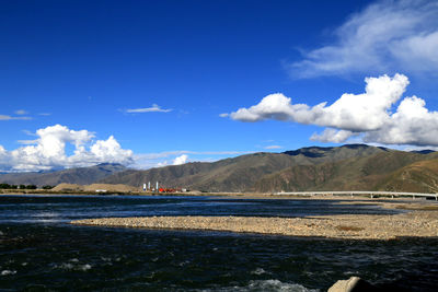 Scenic view of road by mountains against sky