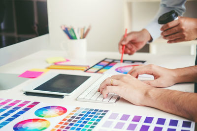 Midsection of man making painting on table