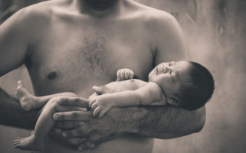 Midsection of shirtless man with baby boy