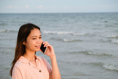 Portrait of young woman standing on beach