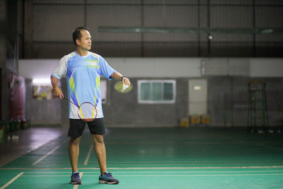 Full length of man holding ball while standing in park