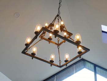 Low angle view of illuminated pendant lights hanging from ceiling