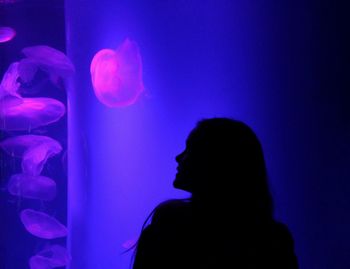 Silhouette woman swimming in aquarium