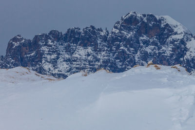 Snowy slope with the dolomite peaks in the background, belluno, italy