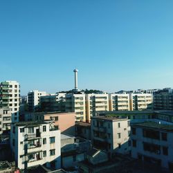 High angle view of buildings against clear blue sky