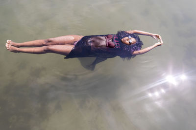 High angle view of young woman floating in sea