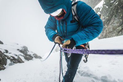 Man with umbrella on snow covered mountain