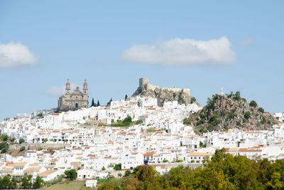 Buildings in town against sky