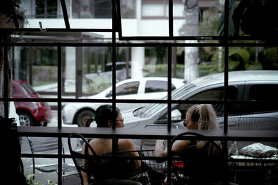 Rear view of woman seen through glass window