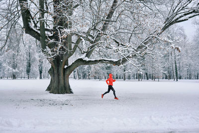 Running woman, girl runner on snow in park winter day. run, sport concept, leisure and freedom.