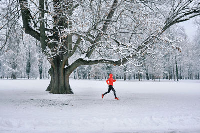 Full length of woman walking on snow covered field