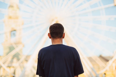 Rear view of man standing against building