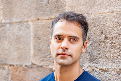 Portrait of man standing against wall