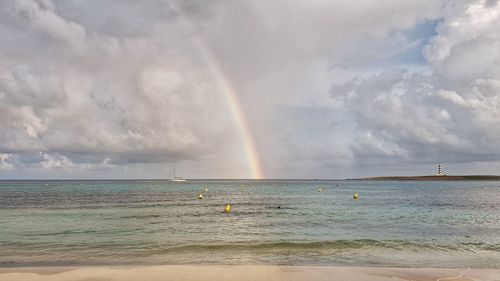 Scenic view of sea against rainbow in sky