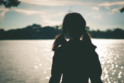 Woman standing by sea against sky