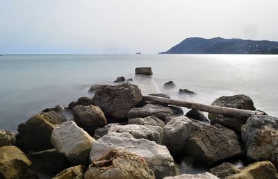 Rocks on sea shore against sky