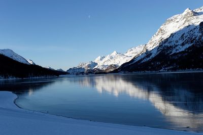 Scenic view of lake and mountains against blue sky