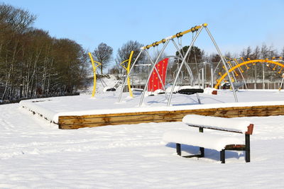 Built structure on snow covered trees against sky