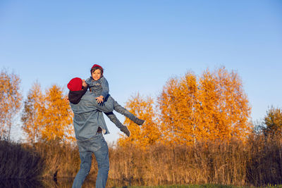 Portrait of a village boy child and father in red hats throws up into the sky