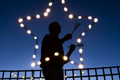 Low angle view of silhouette man standing against sky