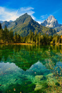 Scenic view of lake by mountains against sky