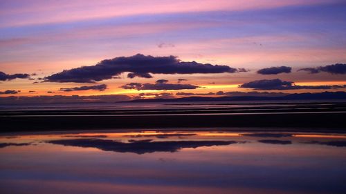 Reflection of clouds in sea at dusk